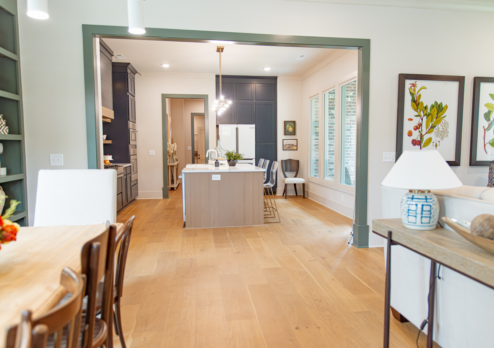 St. Jude Giveaway House 2025 Dining Room looking into kitchen, with warm wood tones, natural light, and art work.