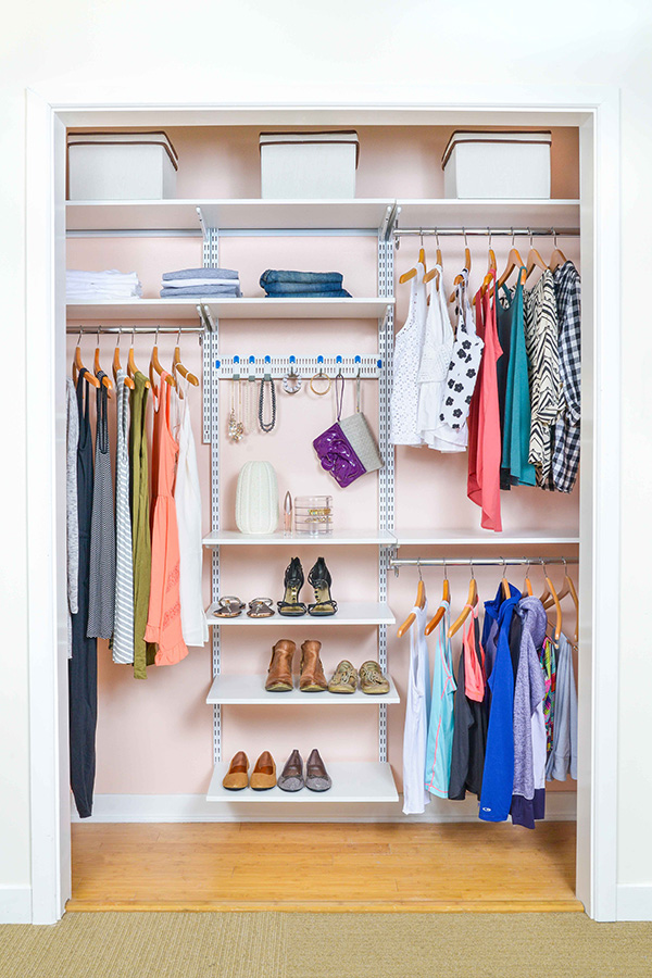 freedomRail reach-in closet in Driftwood Live with boys clothing, toys, and storage baskets.
