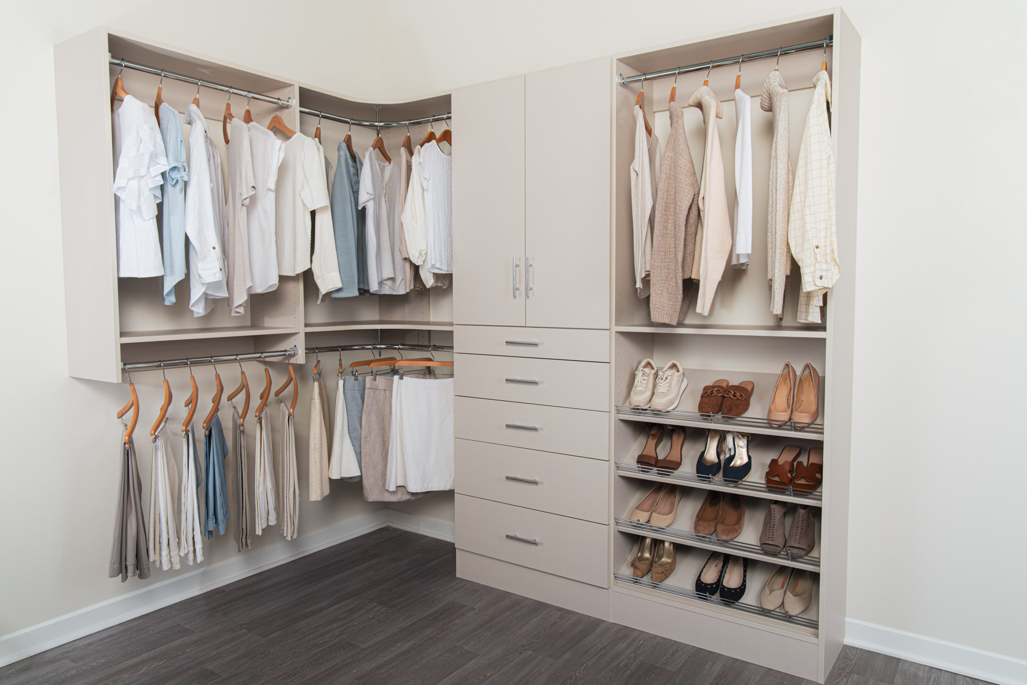Truffle Classica closet by Organized Living propped with female neutral toned clothing.